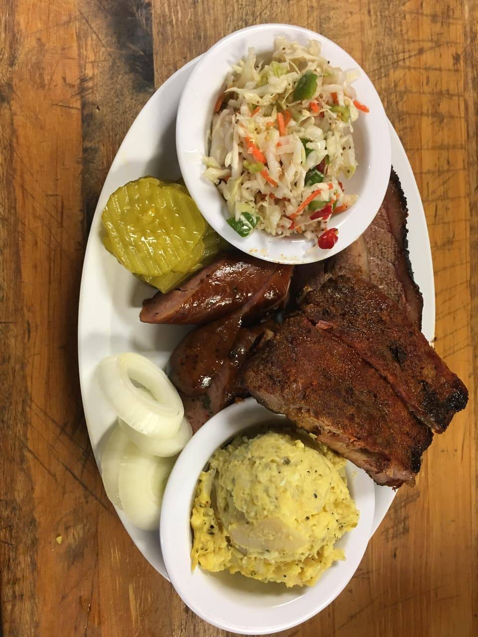 Smoked Texas-style ribs served with brisket, sausage, and homemade sides at R & R BBQ