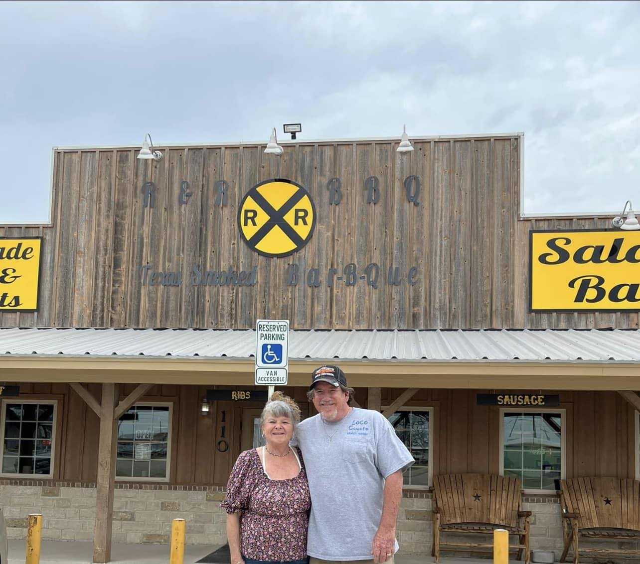 Rod and Tammy standing outside R & R BBQ's storefront on Morgan Mill Rd in Stephenville, TX